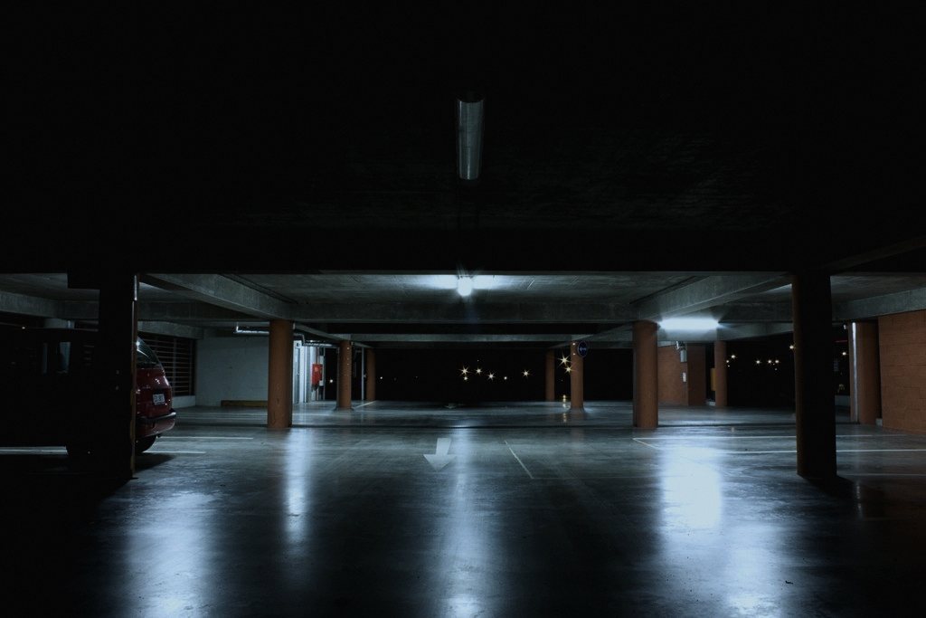 Set in a fictional multi-storey car park on an invented Cathcart Street, chosen because night-shift barrier work is mundane and specific enough to carry a rule list without needing a haunted building.
