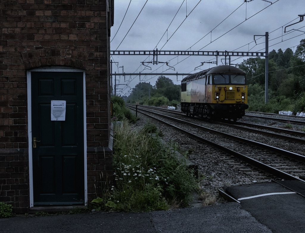 Set on a decommissioned rail crossing outside a small English town, chosen because disused infrastructure still half-behaves like it's working is quietly unsettling without needing a haunted building.