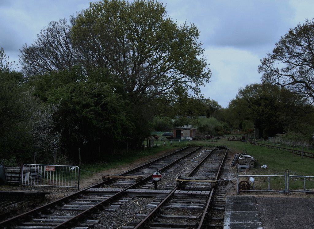 ตั้งอยู่ที่สถานีรถไฟเล็กชานเมืองก่อนถึงตัวอำเภอ เพื่อให้ภาพชนบท-กึ่งเมืองของทางข้ามรถไฟไม่มีเครื่องกั้นดูสมจริงและอ้างอิงได้กับพื้นที่แบบนี้ทั่วประเทศ