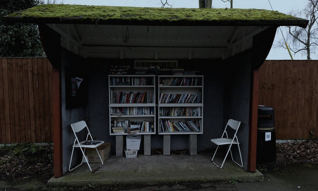 Set in a fictional English village on a lane called Fenn, chosen because parish noticeboards there still carry real handwritten notices, the kind of ordinary object easy to walk past without reading twice.